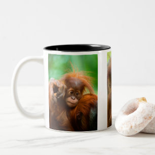 Niedliches Baby Orangutan mit Blick nach vorne Zweifarbige Tasse