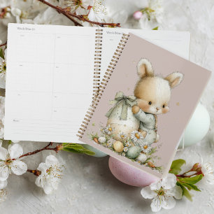 Niedliches Babykaninchen in Schlafanzug mit einem Planer
