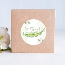 Niedliches grünes Baby gewinnt zwei Erbsen in eine