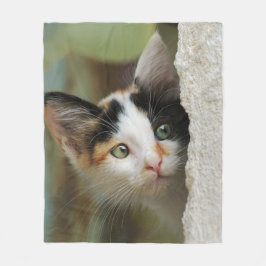Niedliches neugieriges Kätzchen-einmischende Fleecedecke