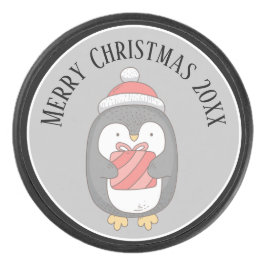 Niedliches Weihnachtspenquin mit Hut und Packung Eishockey Puck