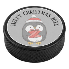 Niedliches Weihnachtspenquin mit Hut und Packung Eishockey Puck