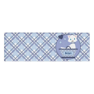 Niedliches weißes Jungenkätzchen im Korb mit Namenschild