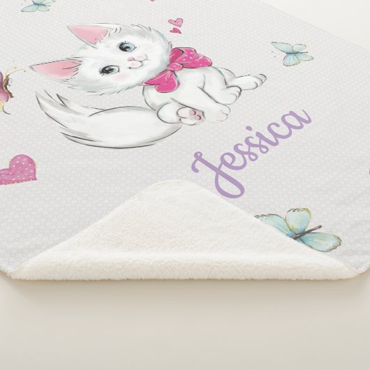 Niedliches weißes Kätzchen mit Schmetterling auf Sherpadecke (3/4)