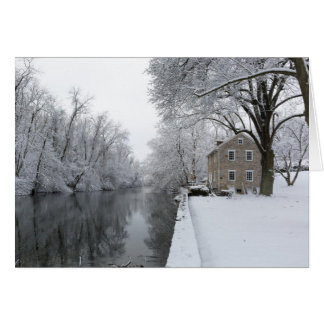 Noch Haus entlang ruhigem Wasser im Schnee