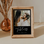 NOIR MINIMALISTISCH FOTO TISCHNUMMER 12X18<br><div class="desc">Die NOIR Collection zeichnet sich durch eine klassische Schwarz-Farbe und einen atemberaubenden modernen Kalligraphie-Script-Schriftart aus, der ein elegantes und elegantes Aussehen schafft. Diese Kollektion ist ideal für Paare, die gewollt haben, ein zeitloses und klassisches Ambiente für ihre besondere Veranstaltung zu schaffen. Das fett schwarze Farbschema schafft einen auffallenden Kontrast zum...</div>