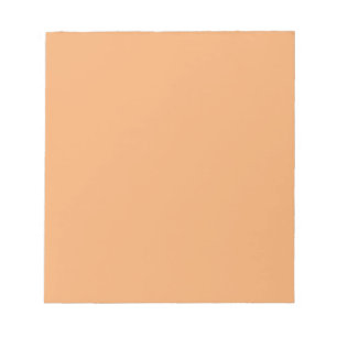 Notepad mit pastellfarbenem Orange-Hintergrund Notizblock