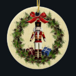 Nutcracker Wreath Custom Round Christmas Ornament<br><div class="desc">Schöne rote Nusscracker Puppe in Kranz um Frohe Weihnachten personalisierten Ornament. An der Vorderseite dieses hübschen zweiseitigen Keramik-Ornaments befindet sich ein roter Nussknacker inmitten eines Kranzes mit Kiefern, Beeren und einem rot-goldenen Bogen. Die Rückseite hat auch einen schönen Kranz und Bogen und ist bereit für Sie, einen Namen und Jahr...</div>