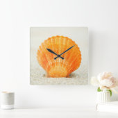 Orange Scallop Shell Standing Upright In Sand Quadratische Wanduhr (Zuhause)
