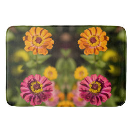 Orange und rosa Zinnien in Blüte Badematte