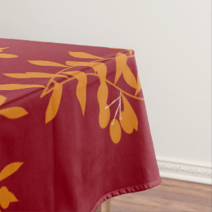Orangefarbene Blätter der Silhouette auf rot Tischdecke