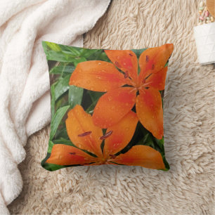 Orangefarbene Blume mit grünen Blätter Kissen