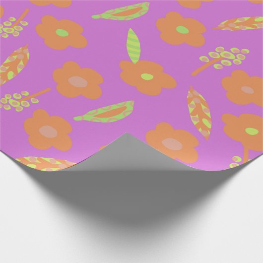 Orangefarbene Blume und grüne Linse auf hellrosa Geschenkpapier (Ecke)