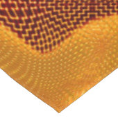 Orangefarbene Kurve und goldene Punkte auf braunem Tischdecke (Schrägansicht)