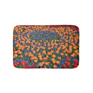 Orangefarbene Tulpen und Muscari-Blume Badematte