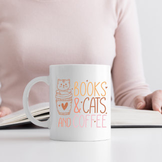 Orangefarbene und rosafarbene Bücher und Katzen un Kaffeetasse