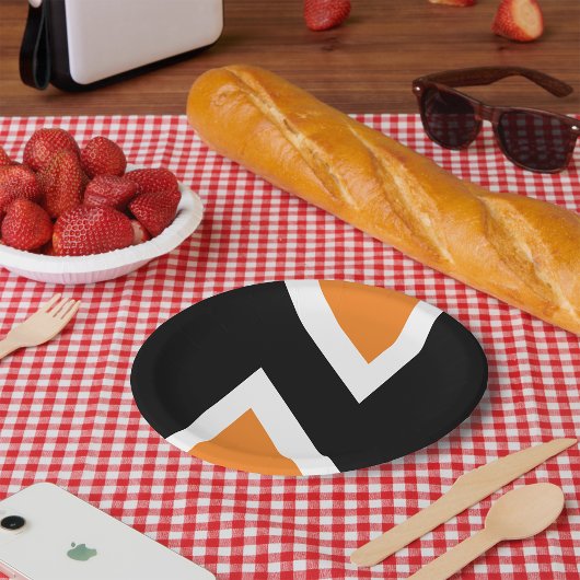 Orangefarbene und schwarze Buchstaben in Papierfor Pappteller