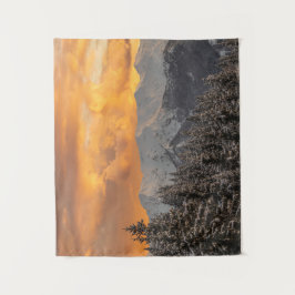 Orangefarbene Wolken über Bergen und Fichtenwald Wandteppich