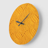 Orangefarbener Pullover, texturierter Hintergrund. Große Wanduhr (Winkel)