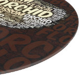 Orchideen-Blumenblüte über Burgunder-Wort-Wolke Schneidebrett (Ecke)