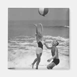 Paar spielt mit einem Strandball Magnet