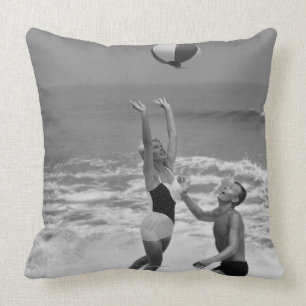 Paare, die mit einem Beachball spielen Kissen
