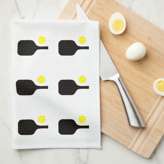 Paddel und gelbe Bälle aus schwarzem Pickleball Geschirrtuch (Viertel Falte)