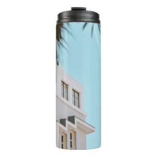 Palmenbaum in der Nähe von weißem Beton Gebäude Thermosbecher