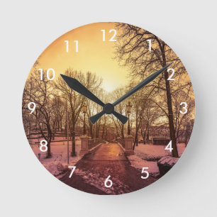 Panoramablick auf den verschneiten Park bei Sonnen Runde Wanduhr