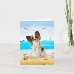 Papillon-Hund am Strand Karte