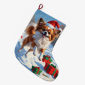 Papillon Hund läuft im Schnee mit Weihnachtshut Großer Weihnachtsstrumpf (Vorderansicht (hängend))