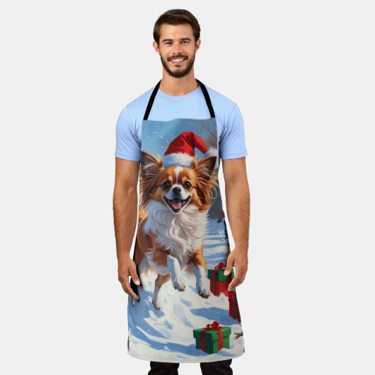 Papillon Hund läuft im Schnee mit Weihnachtshut Schürze (Getragen)