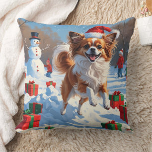 Papillon-Hund läuft im Schnee mit Weihnachtsmütze Kissen
