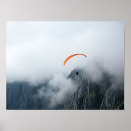 Paragleiter schwebt über neblige Bergklippe Poster