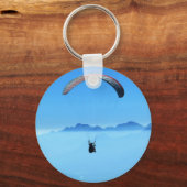 Paraglider auf blauem Hintergrund mit Bergen Schlüsselanhänger (Vorderseite)