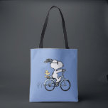 Peanuts | Snoopy & Woodstock Bicycle Tasche<br><div class="desc">Pedal into style and classic charm with this adorable cream canvas tote bag, featuring Snoopy and Woodstock on a bicycle! This fun tote showcases a delightful line-art illustration of Snoopy, wearing sunglasses, happily riding a vintage-style blue bicycle with Woodstock perched safely behind him. The dashed lines behind the back wheel...</div>