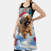 Pekingese Hund läuft im Schnee mit Weihnachtshut Schürze (InSitu)