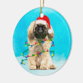 Pekingese Hund sitzend im Schnee Weihnachtshut Lic Keramik Ornament (Links)
