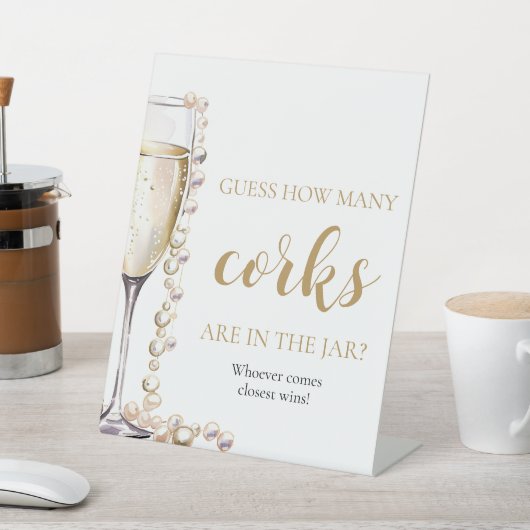 Perlen und Prosecco schätzen, wie viele Corks Spie Sockelschild (In SItu)