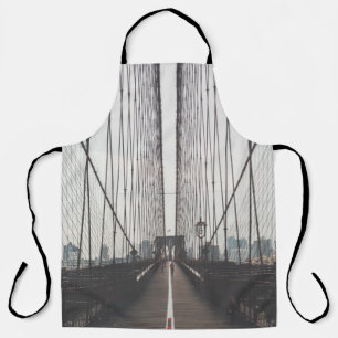 PERSON AUF BRÜCKE SCHÜRZE