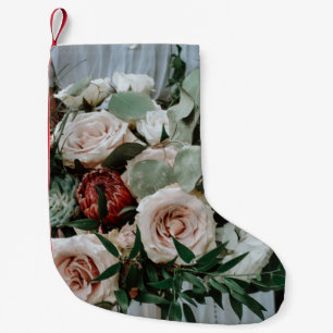 PERSON, DIE DIE ROTE BLUME UND PINKENBOUQUET BESIT KLEINER WEIHNACHTSSTRUMPF