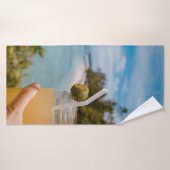 Person, die ein mit Saft gefülltes Massagegefäß in Badehandtuch (Badehandtuch)