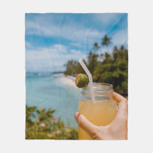 Person, die ein mit Saft gefülltes Massagegefäß in Fleecedecke