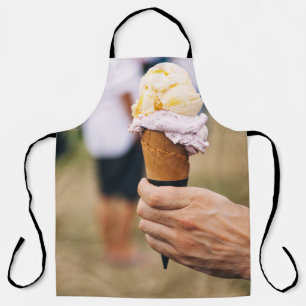 Person, die Eis auf Kegel hält Schürze