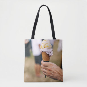 Person, die Eis auf Kegel hält Tasche