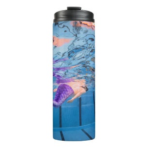 Person in lila Hosen auf blauer Hängematte Thermosbecher