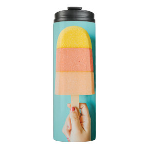 Person mit gelbem und braunem Eis Thermosbecher