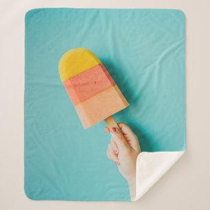 Person mit gelbem und rosa Popsiv Sherpadecke