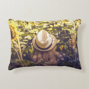 Person mit weißem Hut neben Sonnenblumenfeldern Dekokissen