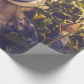 Person mit weißem Hut neben Sonnenblumenfeldern Geschenkpapier (Ecke)